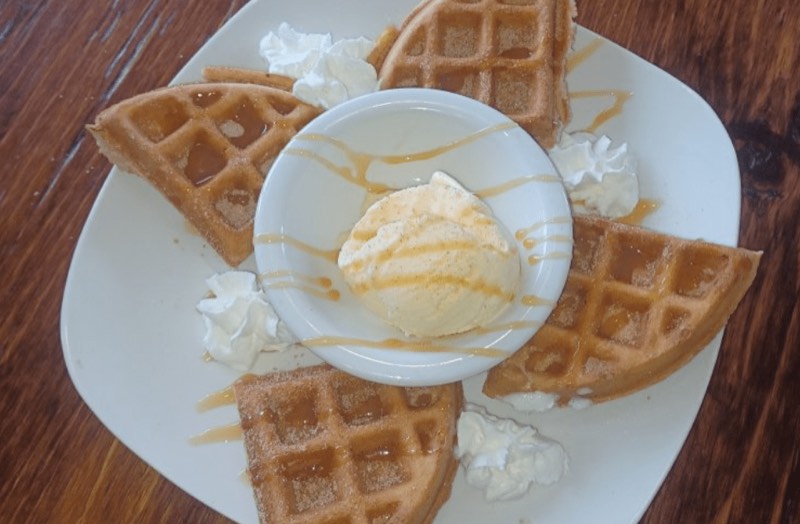 Waffle quarters around a scoop of whipped butter, drizzled with caramel.